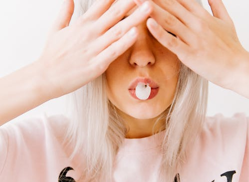 A woman blowing a chewing gum