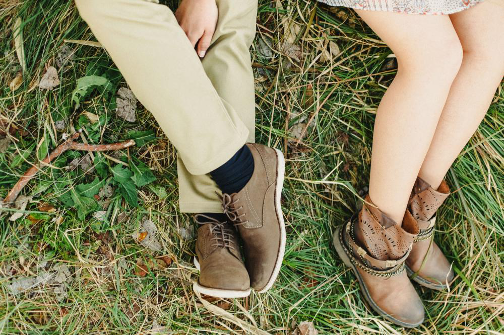 A top view of a man and a woman wearing leather shoes 