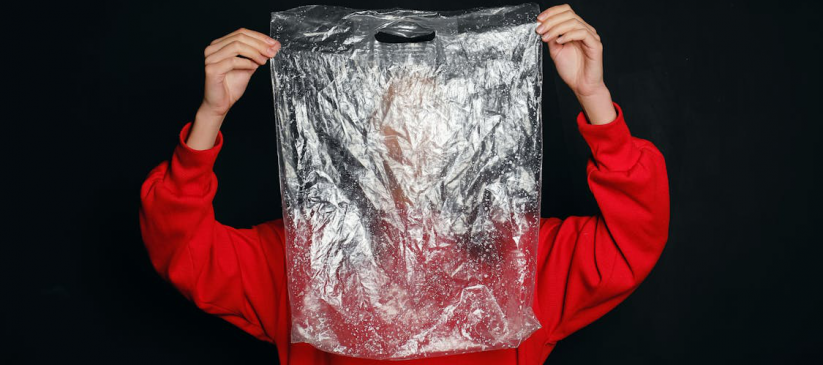 A man in a red shirt holding a plastic bag