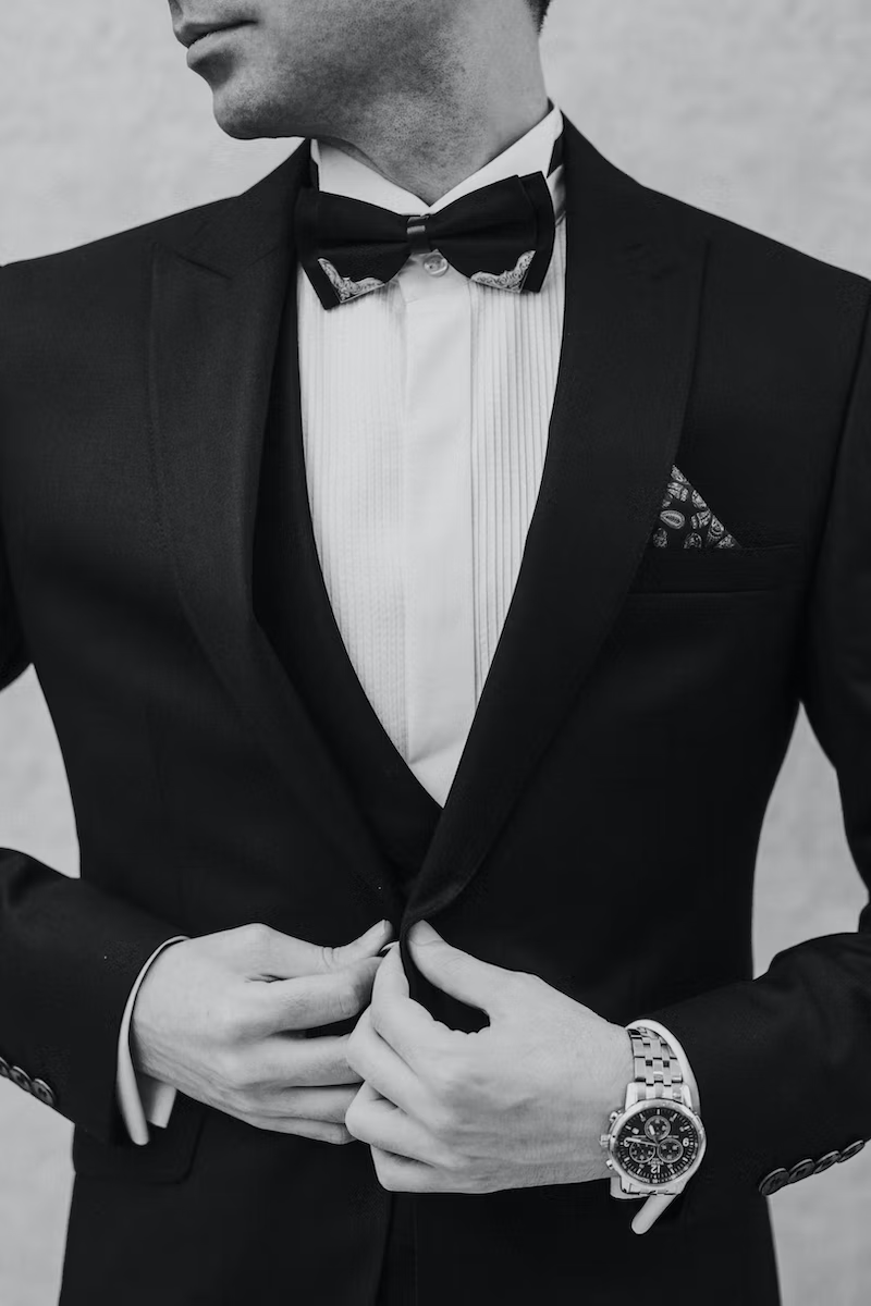 A closeup of a man holding his Tuxedo