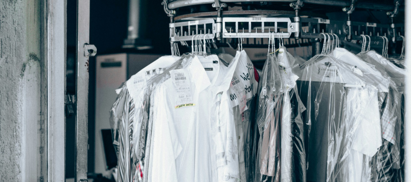 clothes wrapped in clear plastic hanging on a rack